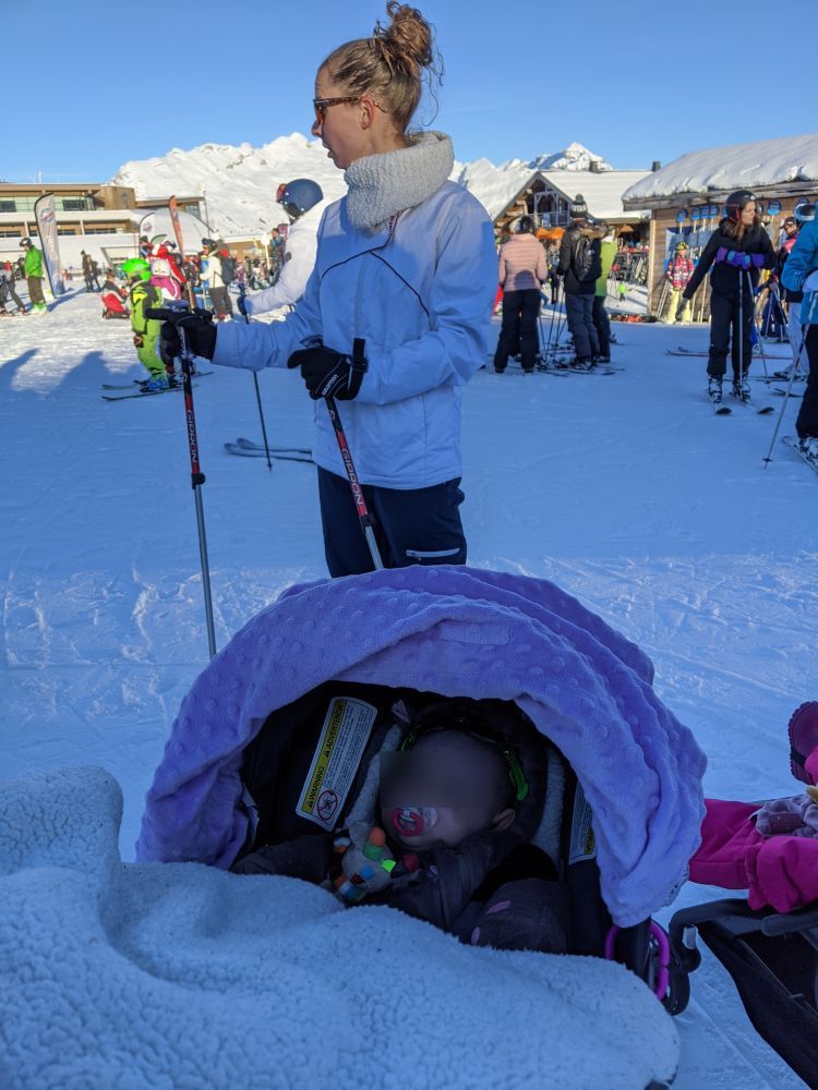 Maman à skis, bébé en poussette